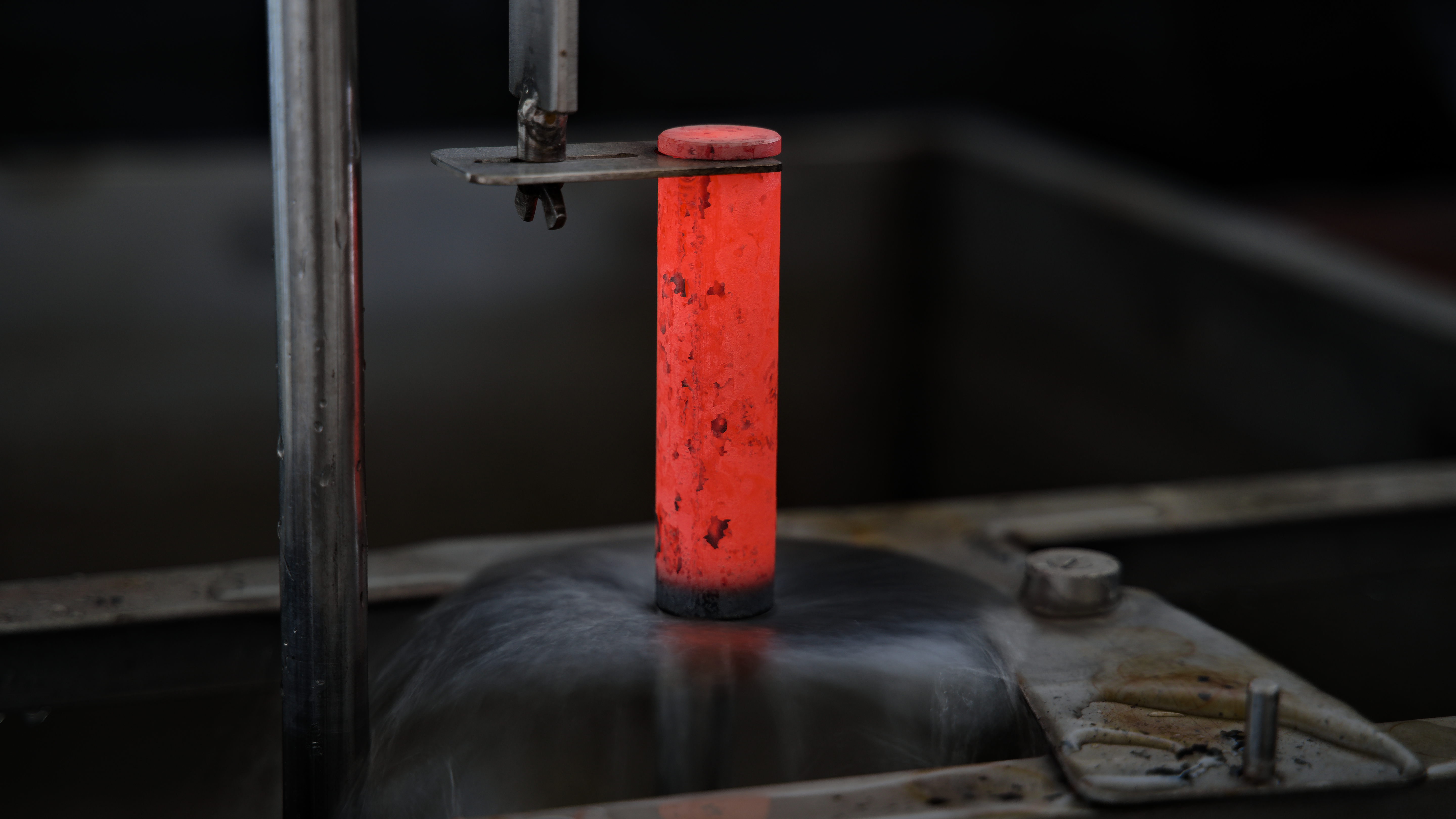 Eine glühende Rundprobe wird von unten mit Wasser bestrahlt.